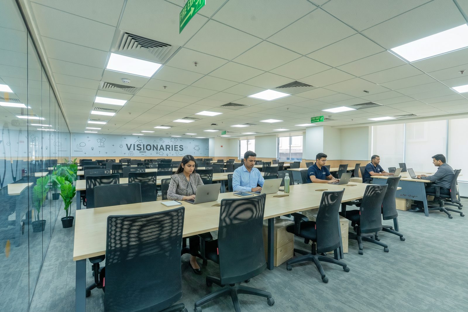BHIVE open coworking desk floor with the Visionaries wall graphic