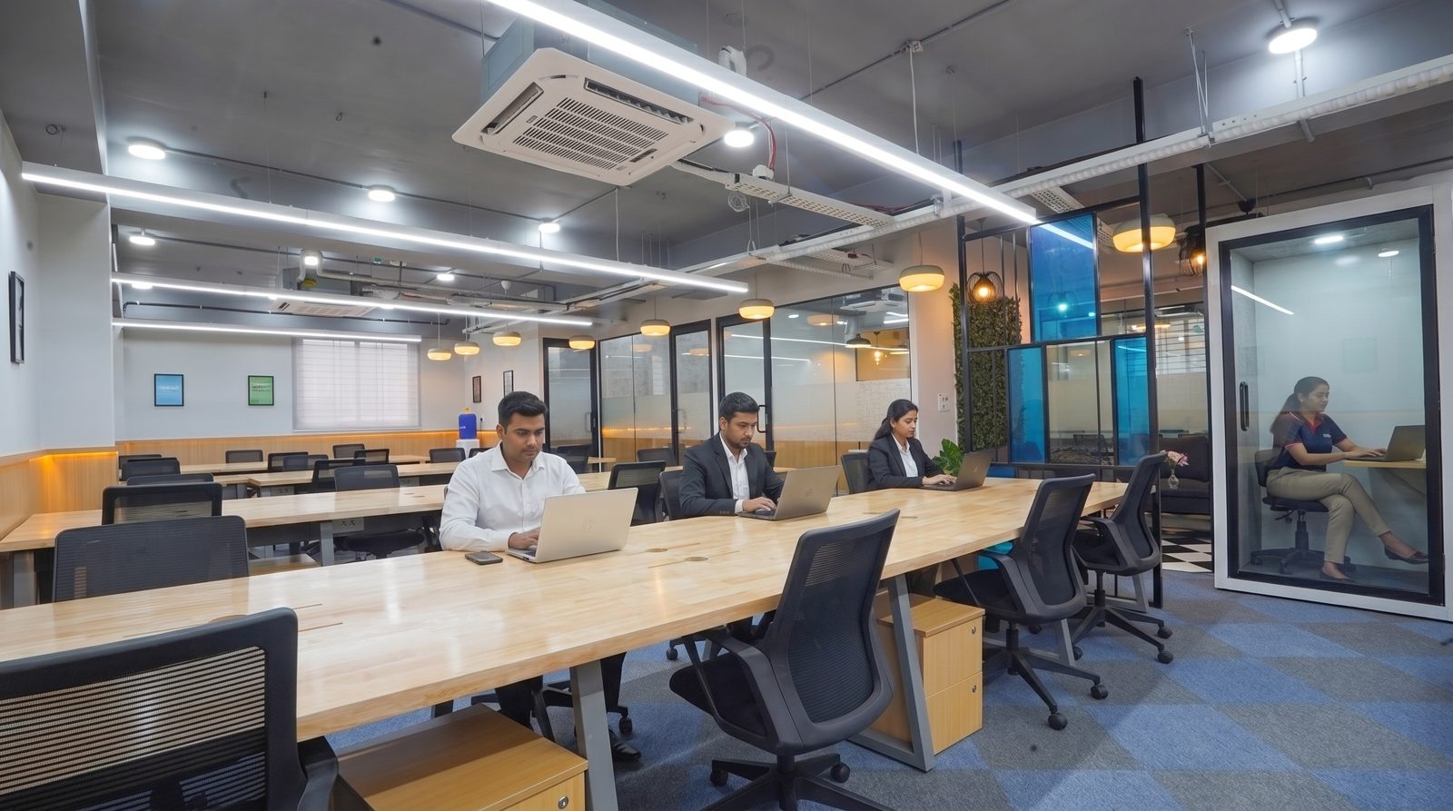 BHIVE open desks beside a glass phone booth